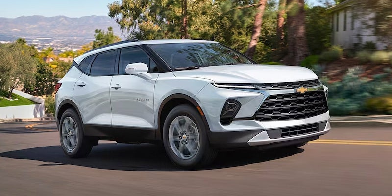 A 2024 Chevrolet Blazer driving on a road, showcasing its sleek design and powerful presence.