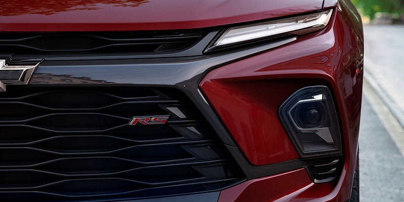 Front grille of a red 2024 Chevrolet Blazer showcasing its sleek design and bold styling.