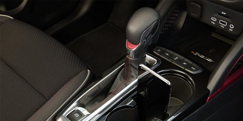 Close-up of a car's gear shift, showcasing the design and layout of the gear lever and surrounding controls.